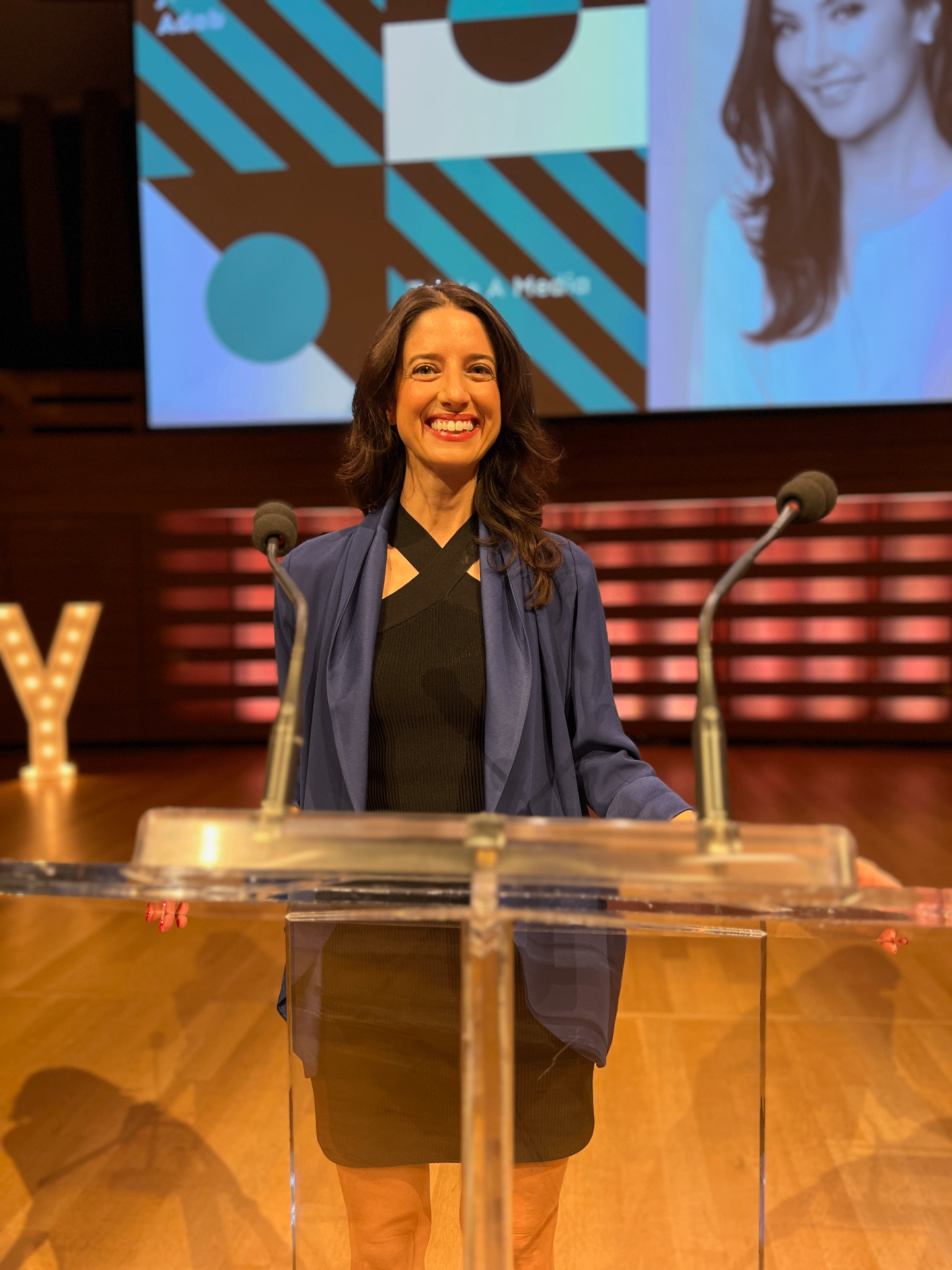 Fiona speaking on stage at a podium
