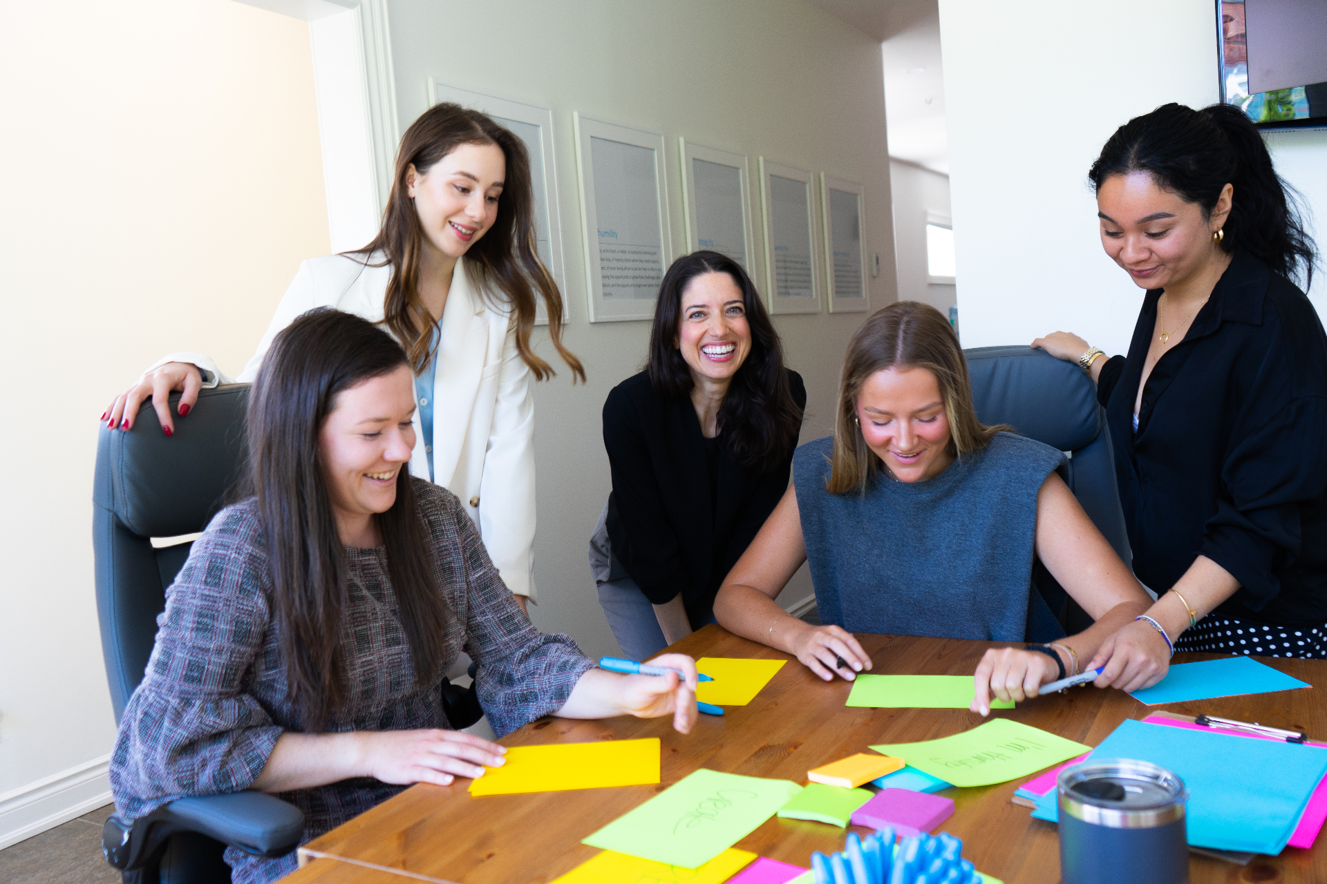 Fiona Stevenson facilitating a creative workshop with a team around a table of colorful sticky notes